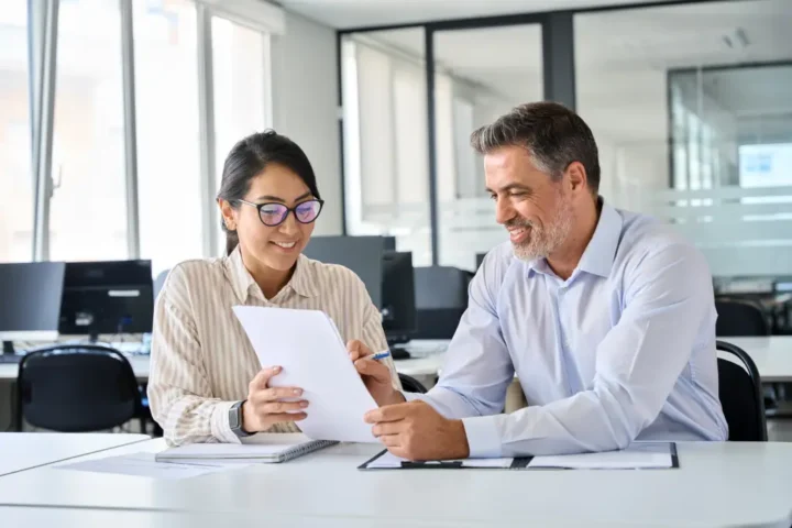 business professionals sitting at desk reviewing form